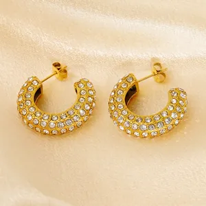 Fashionable gold C-shaped stainless steel earrings with sparkling rhinestones on satin