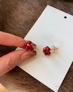 Detail of red berry stud earrings with gold plating and white zircon cluster