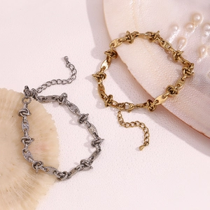 Detail of coffee bean link anklet in gold and silver finish with adjustable clasp