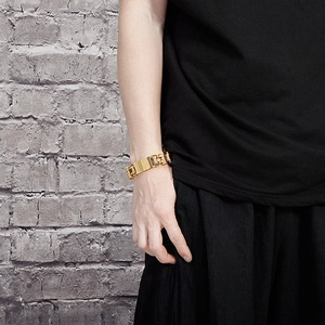 Macro view of gold stainless steel thick curb chain bracelet with engravable ID tag