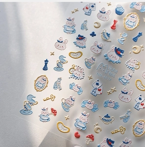 Detail of 3D embossed nail stickers featuring blue rabbit and Alice theme elements