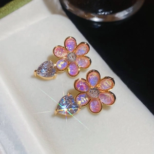 Detailed close-up of pink flower petal resin earrings with a sparkling heart zircon stone