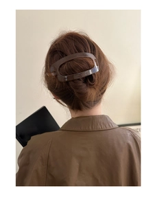 Pince à cheveux en résine écaille de tortue marron foncé sur un modèle élégant