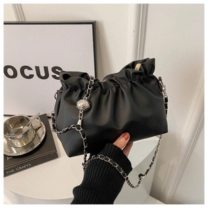 Detailed shot of pleated black cloud bag with silver chain and metal ball ornament
