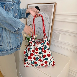 Detail of floral tote bag with red rose pattern and comfortable rope handle for daily use