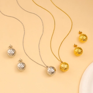 Macro shot of 3D football pendant necklace and earrings set in gold and silver finish