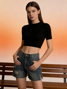 Tenue d'été à la mode avec crop top noir et short en jean effiloché sur un mannequin