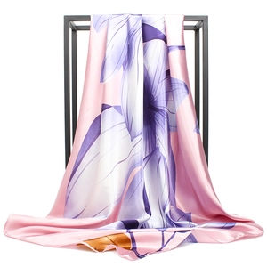 Pink satin square scarf with purple floral print draped on a black metal display stand