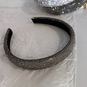 Dettaglio macro del cerchietto imbottito con strass grigio antracite e texture brillante