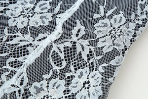 Gros plan détaillé sur la broderie en dentelle florale blanche d'une robe ajustée col en V