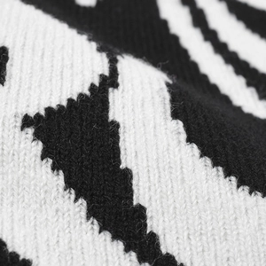 Close-up macro shot of black and white jacquard knit fabric texture of a beanie