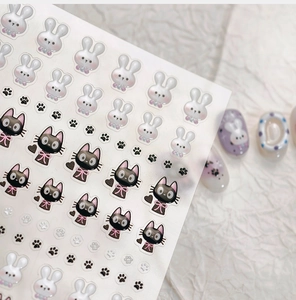 Detail of 3D embossed nail stickers featuring white rabbits and black cats designs