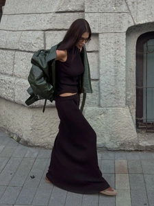 Deep brown knitted vest and skirt set with an olive green matte jacket in a street style