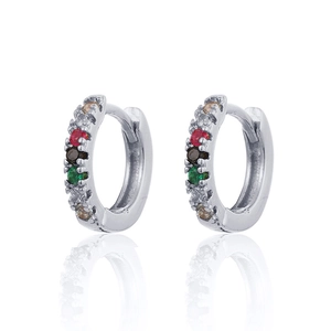 Detailed view of silver hoop earrings inlaid with colorful zircons and mirror reflection