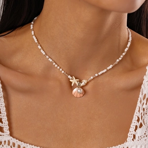 Detail of seashell and starfish pendants on a summer beaded pearl necklace for women