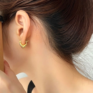 Close-up of 18K gold plated heart and V-shaped hoop earrings with micro zircon inlays