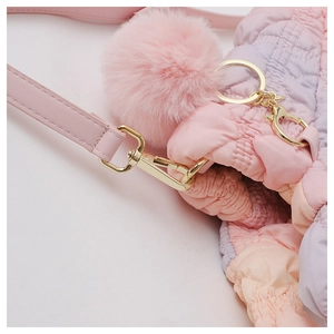 Detail of pink and purple gradient quilted bag with gold hardware and pink pom-pom charm