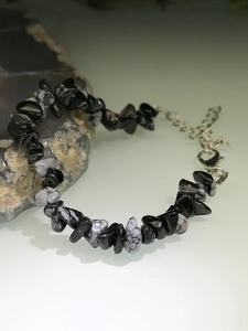 Macro detail of natural irregular black and white stone bracelet with silver extender chain