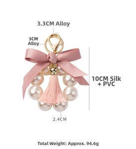 Detail of pink bow keychain with pearl ring, tassel and alloy size specifications