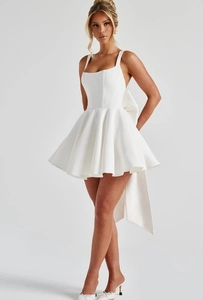 Detail shot of the oversized white bow and long flowing sash on the back of the dress
