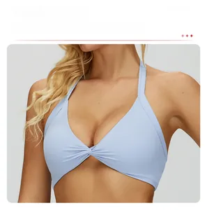 Light blue halter sports bra with a front twist knot and removable chest pads detail