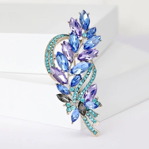 Close-up of luxury crystal barley brooch with blue marquise gemstones and silver plating