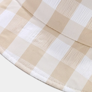 Détail de la texture seersucker à carreaux beige et coutures fines du bord du chapeau