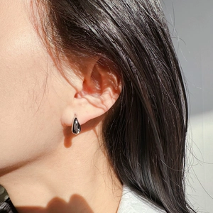 Boucle d'oreille goutte d'eau argentée minimaliste avec fini métal liquide sur l'oreille
