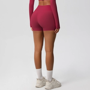 Detail of high-waisted seamless burgundy yoga shorts showing lift and fabric texture