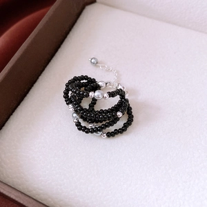 Detail of multi-layer black glass bead ring with adjustable silver extension chain