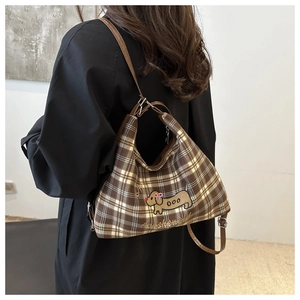 Detail showing brown plaid canvas tote with cute dachshund embroidery and PU strap