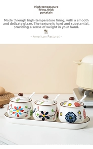 Hand-painted ceramic seasoning jars set with floral patterns on a ceramic tray