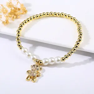 Close-up of gold-plated beaded bracelet with micro-pave bear charm and pearls