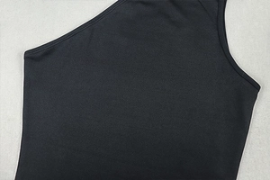 Detail shot of black knitted dress fabric showing collar seams and textured stitching