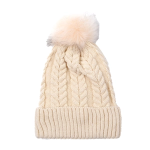 Détail du bonnet en maille torsadée avec pompon en fourrure et revers épais côtelé
