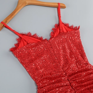 Detail view of red sequin dress with V-neck lace trim and adjustable spaghetti straps