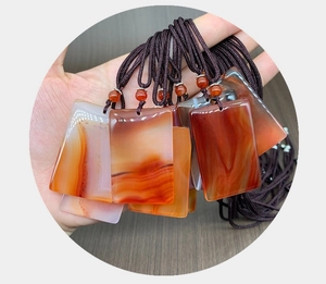 Detail of a natural red agate pendant with unique silk textures and braided rope cord
