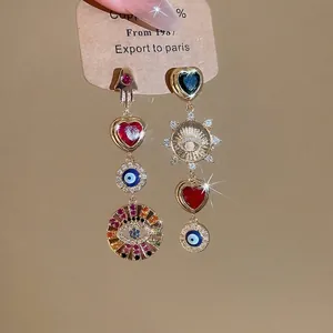 Asymmetric gold earrings with colorful hearts, Hamsa hand and Evil Eye folk elements