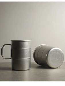 Close-up of matte 304 stainless steel camping cup showing smooth rolled edge and foldable handle