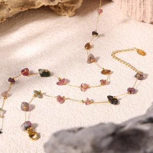 Detail of bohemian necklace with colorful natural crushed stones and gold stainless steel