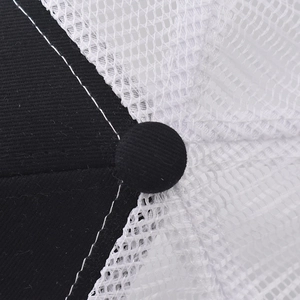 Detailed close-up of the black and white trucker hat top with mesh and reinforced seams
