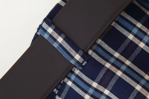 Detail aus blauem Karostoff kombiniert mit dunkelbraunen Leder-Nähten