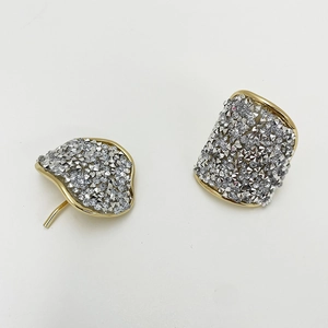 Elegant gold-tone irregular curved earrings with full crystal pave on white background