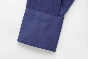 Close-up of navy blue shirt cuff featuring fine stitching and premium cotton texture