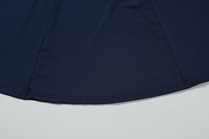 Detail of the navy blue dress hem showing high-quality double-needle flat stitching finish