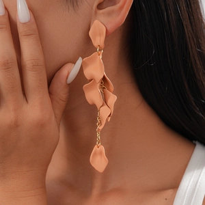 Macro shot of long resin petal earrings in peach tone with golden chain links