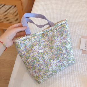 Detail of floral tote bag showing lavender handles and vintage metal button closure
