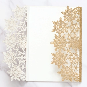 Detailed laser-cut snowflake wedding invitation card with gold glitter and white inner paper