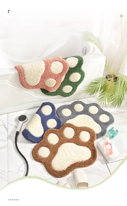 Detailed close-up of fluffy cat paw bath mats in various colors with absorbent fiber texture