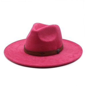 Close-up of fuchsia suede fedora featuring brown leather band with ethnic embossing